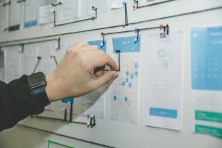 person-working-on-blue-and-white-paper-on-board.jpg person working on blue and white paper on board